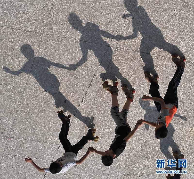 Several young practice roller skating, and their shadows just dance along with them. (Photo/Xinhua)