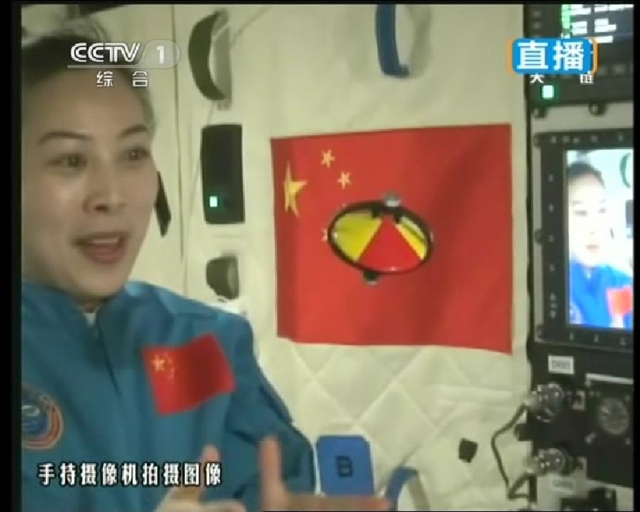 This TV grab taken on June 20, 2013 shows female astronaut Wang Yaping, one of the three crew members of Shenzhou-10 spacecraft, demonstrating gyroscopic motion in space during a lecture to students on Earth aboard China's space module Tiangong-1. A special lecture began Thursday morning, given by Wang Yaping aboard China's space module Tiangong-1 to students on Earth. (Xinhua)