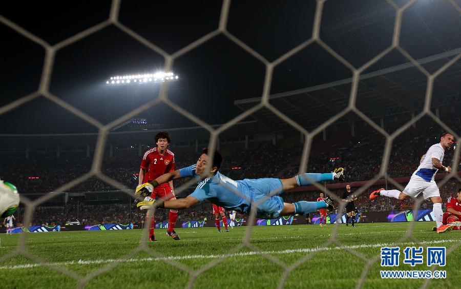 Chinese team goalkeeper Zeng Cheng dives for the ball in the contest during their international friendly soccer match at the Workers Stadium in Beijing, capital of China, June 11, 2013. (Photo/Xinhua)