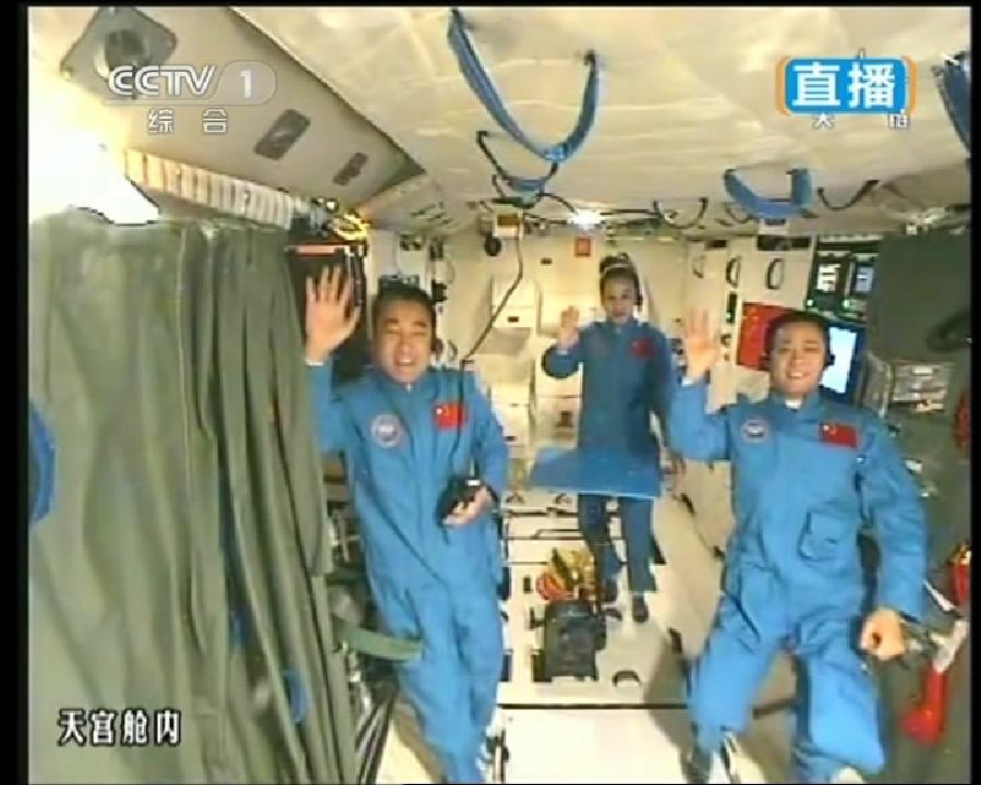 This TV grab taken on June 20, 2013 shows the three crew members of Shenzhou-10 spacecraft waving at the end of a lecture to students on Earth, aboard China's space module Tiangong-1. A special lecture began Thursday morning, given by Wang Yaping aboard China's space module Tiangong-1 to students on Earth. (Xinhua)