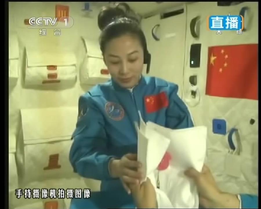 This TV grab taken on June 20, 2013 shows female astronaut Wang Yaping, one of the three crew members of Shenzhou-10 spacecraft, collecting a water ball with sheets of paper in the space during a lecture to students on Earth aboard China's space module Tiangong-1. A special lecture began Thursday morning, given by Wang Yaping aboard China's space module Tiangong-1 to students on Earth. (Xinhua) 