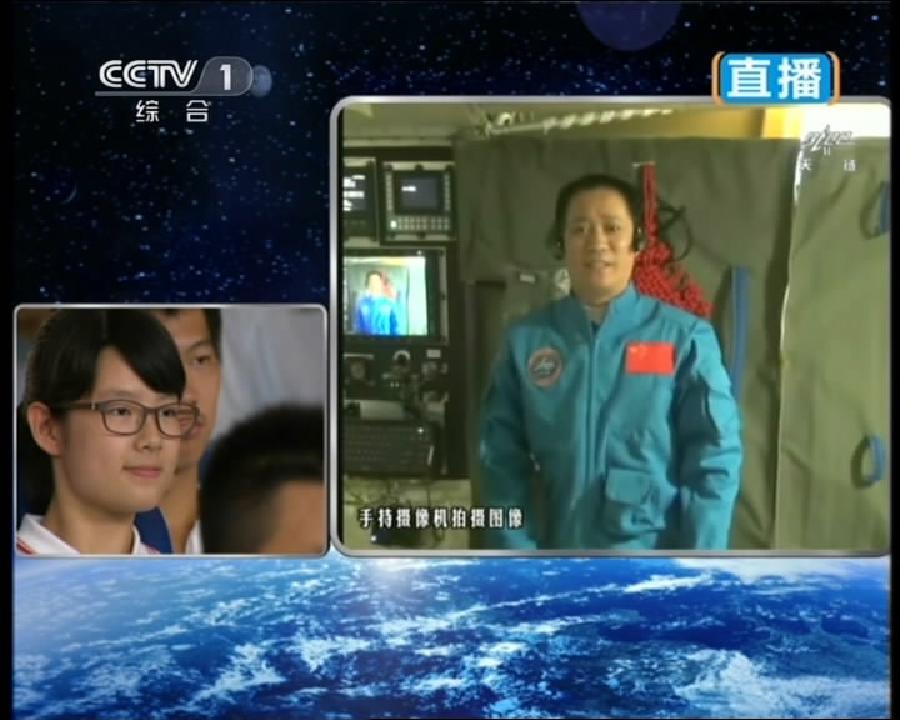 This TV grab taken on June 20, 2013 shows astronaut Nie Haisheng (R), one of the three crew members of Shenzhou-10 spacecraft, interacting with a student on earth during a lecture to students on Earth aboard China's space module Tiangong-1. A special lecture began Thursday morning, given by Wang Yaping aboard China's space module Tiangong-1 to students on Earth. (Xinhua) 