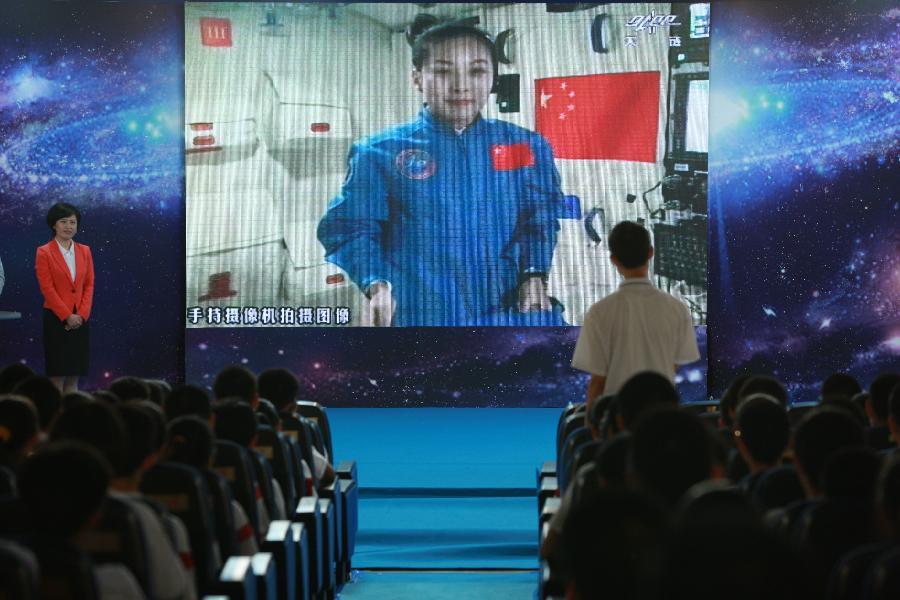 A student asks questions to the female astronaut Wang Yaping, one of the three crew members of Shenzhou-10 spacecraft, at the High School Affiliated to Renmin University of China, in Beijing, capital of China, June 20, 2013. A special lecture began Thursday morning, given by Wang Yaping aboard China's space module Tiangong-1 to students on Earth. (Xinhua/Wang Yongzhuo)