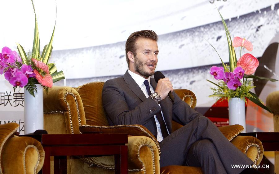 Former England soccer captain David Beckham smiles during a news conference in Shanghai, east China, June 20, 2013. Beckham arrived in China on Monday for a seven-day visit as the ambassador for the Youth Football Programme in China and China's Super League. (Xinhua/Fan Jun)