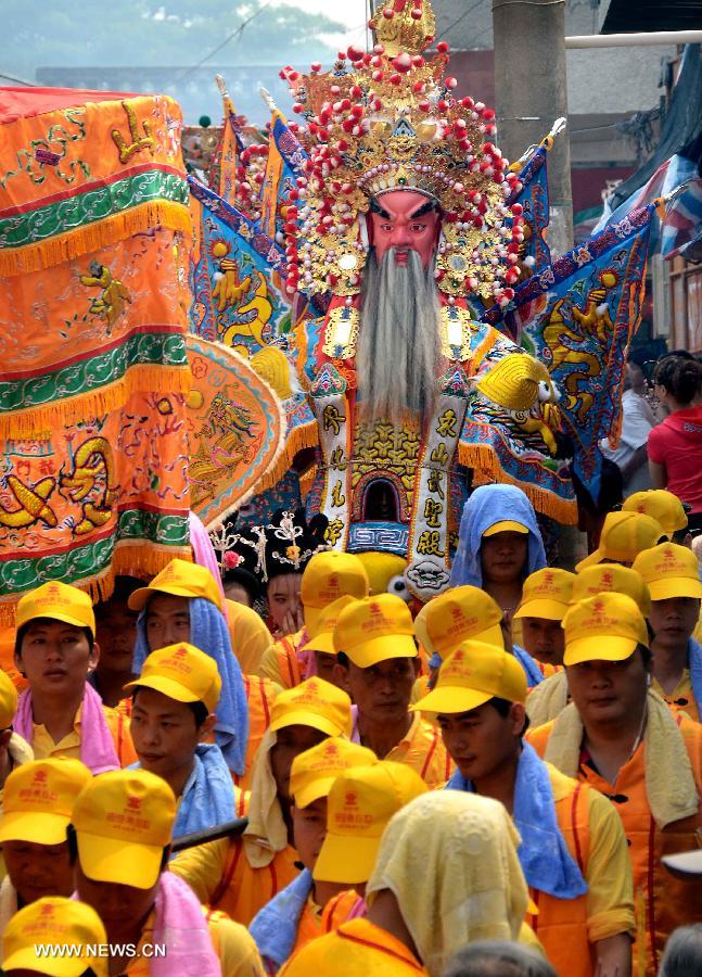 Locals participate in an annual parade honoring Guandi at Tongling Town in Dongshan County, southeast China's Fujian Province, June 20, 2013. Guandi, namely Guan Yu, was a senior general of shu han (221-263) during the three kingdoms period. Guan had been deified by feudal rulers of past ages because of his loyalty to his kingdom and was dubbed "guandi (emperor guan of military strategies)". Guan and confucius, known as the "emperor of education", were usually considered equal in status. (Xinhua/Wang Song)