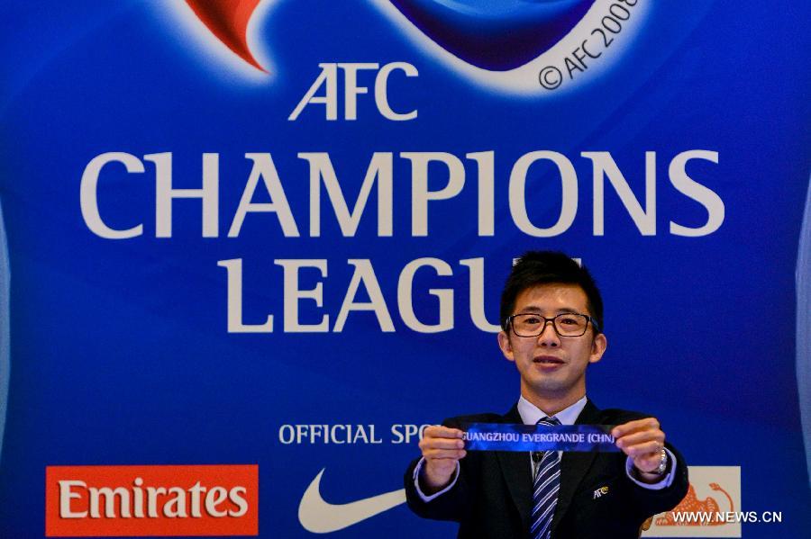 An official holds the paper slip for "Guangzhou Evergrande(CHN)" during the draw for the 2013 AFC Champions League quarterfinals in Kuala Lumpur, Malaysia, June 20, 2013. (Xinhua/Chong Voon Chung)
