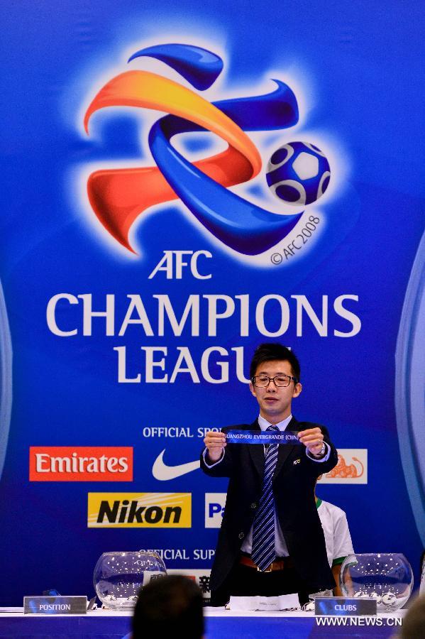 An official holds the paper slip for "Guangzhou Evergrande(CHN)" during the draw for the 2013 AFC Champions League quarterfinals in Kuala Lumpur, Malaysia, June 20, 2013. (Xinhua/Chong Voon Chung)