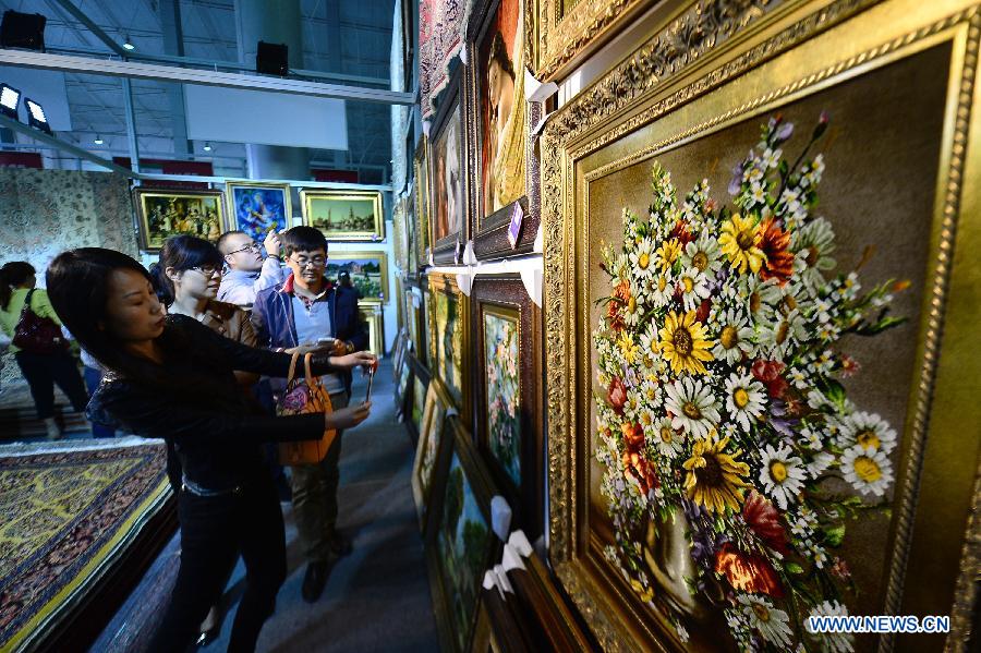 Visitors view decorational carpets at a Tibetan carpet exposition in Xining, capital of northwest China's Qinghai Province, June 20, 2013. Opened Thursday, the exposition attracted some 110 exhibitors from 9 countries. (Xinhua/Wu Gang)
