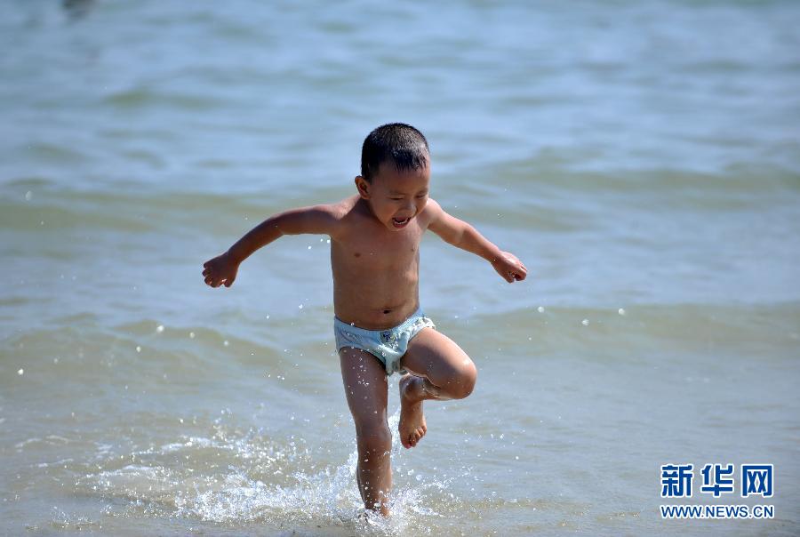 A boy plays at the beach of Beihai in southwest China's Guangxi autonomous region on June 18, 2013. (Photo/Xinhua)
