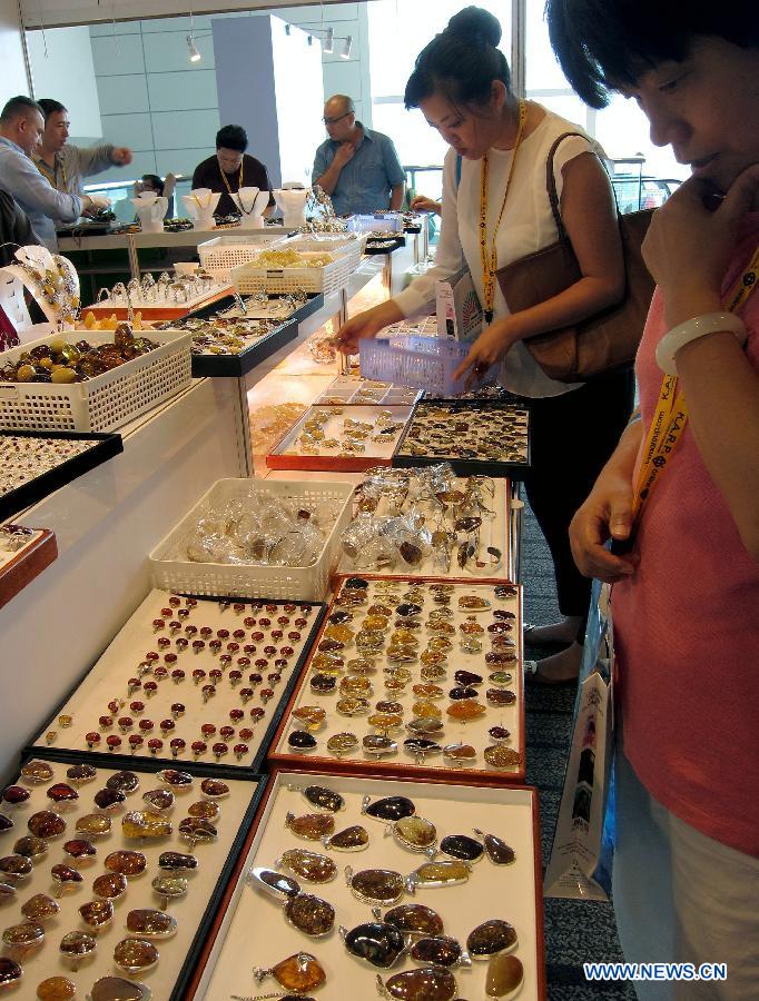 Buyers choose amber jewellery during the Hong Kong Jewellery and Gem Fair held at the convention and exhibition center of Hong Kong, south China, June 20, 2013. A total of 1,841 exhibitors from 37 countries and regions participated in the four-day exhibition that kicked off on Thursday. (Xinhua/Zhao Yusi) 