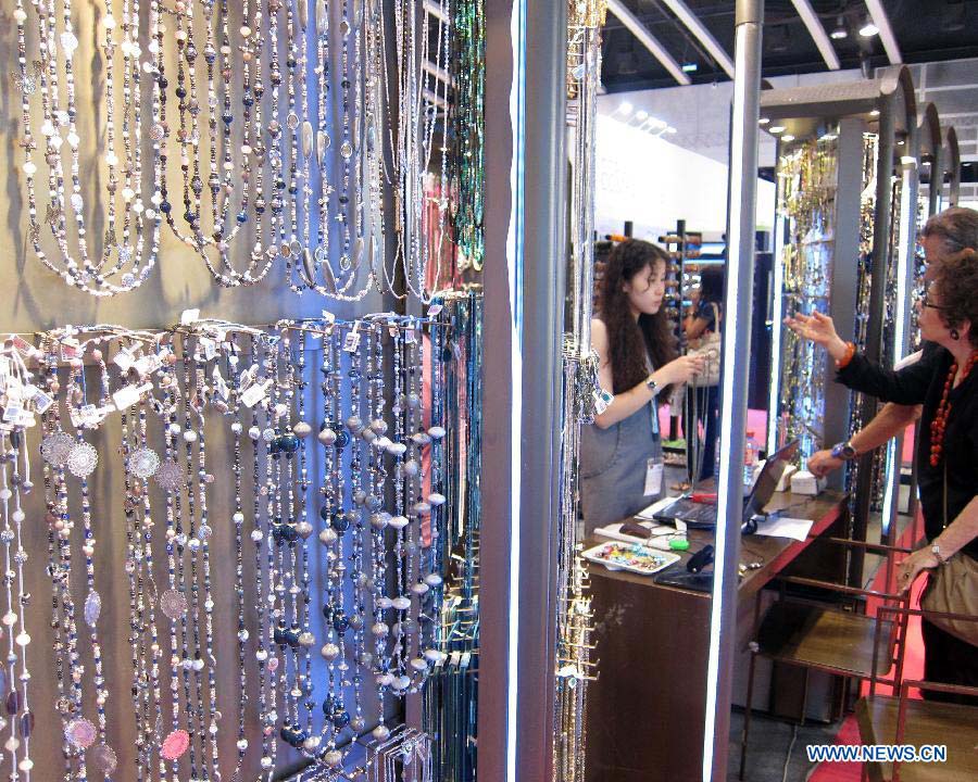 Foreign buyers select jewellery during the Hong Kong Jewellery and Gem Fair held at the convention and exhibition center of Hong Kong, south China, June 20, 2013. A total of 1,841 exhibitors from 37 countries and regions participated in the four-day exhibition that kicked off on Thursday. (Xinhua/Zhao Yusi) 