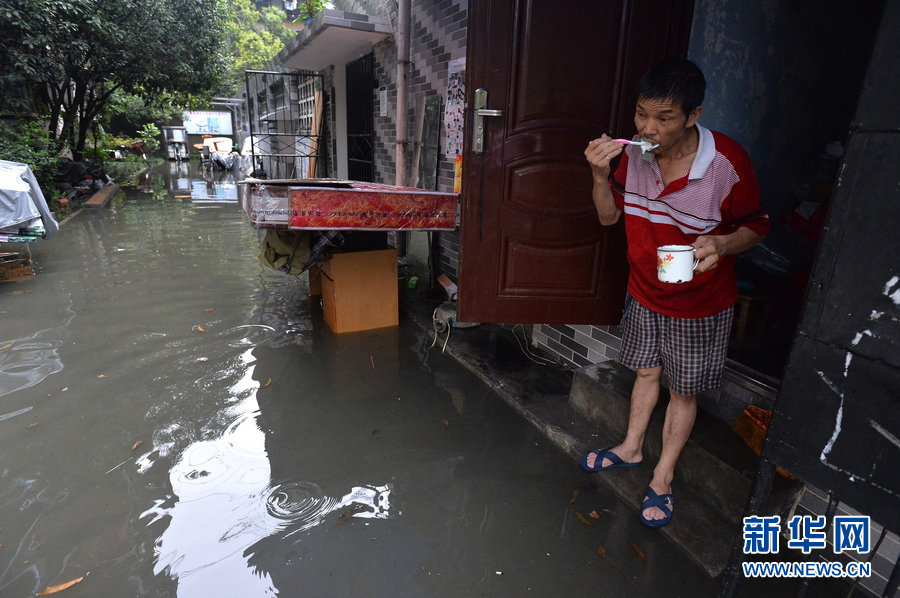 Local residents cope with heavy rainfall as water covered the streets in Chengdu, Southwest China's Sichuan province on June 19, 2013. 