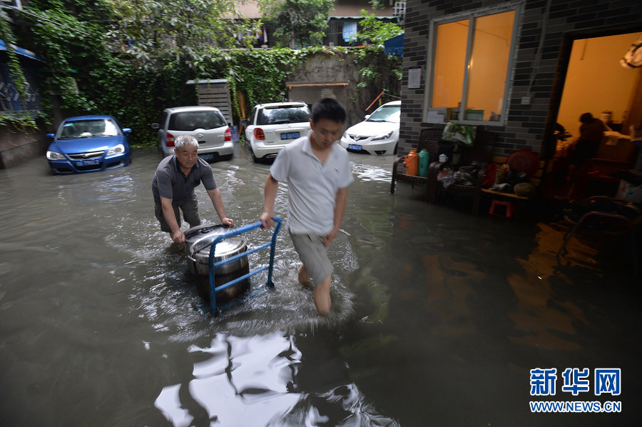 Local residents cope with heavy rainfall as water covered the streets in Chengdu, Southwest China's Sichuan province on June 19, 2013. 