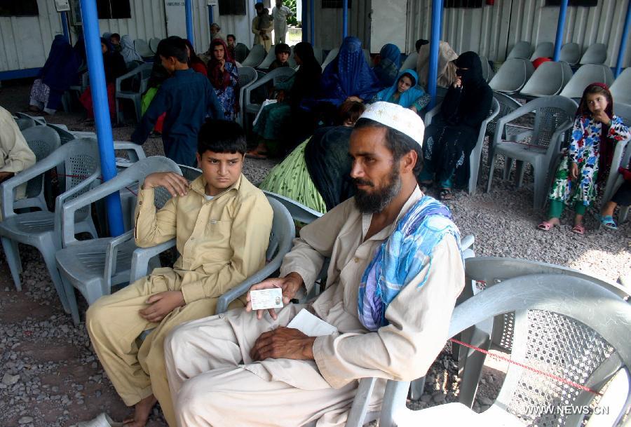 Afghan refugees wait at the office of the United Nations High Commissioner for Refugees (UNHCR) registration center before returning to Afghanistan in northwest Pakistan's Peshawar, on June 20, 2013. Some 45.2 million people worldwide are under forced displacement due to persecution, conflict, generalized violence and human rights violations by the end of 2012, said an annual report released by the United Nations High Commissioner for Refugees (UNHCR) Wednesday. Developing countries hosted over 80 percent of the world's refugees, compared to 70 percent a decade ago, as the report noted, with Pakistan as the country hosting the largest number of refugees worldwide. (Xinhua/Ahmad Sidique)