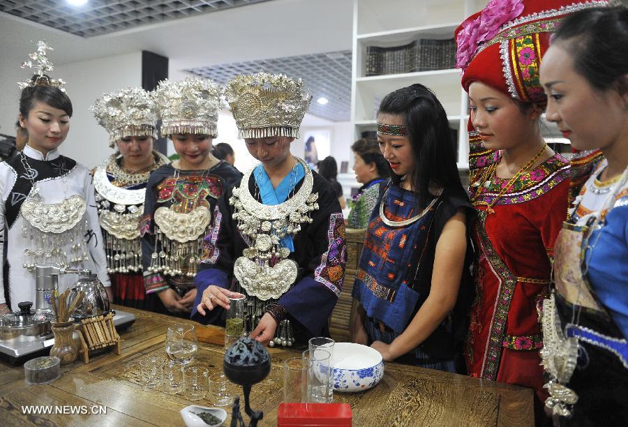 A tea specialist of Miao ethnic group performs tea art during the 7th tea culture festival of Duyun pale-colouredtips in Beijing, capital of China, June 20, 2013. The festival opened here Thursday. (Xinhua/Lu Peng)