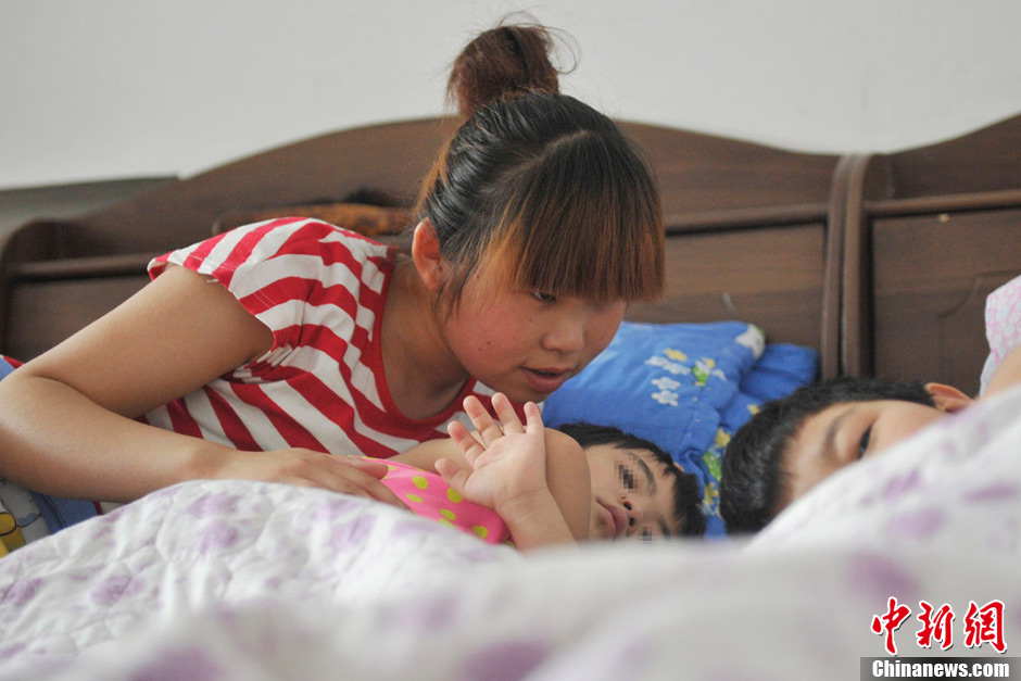 A volunteer looks after the children with autism during lunch break. It has been 5 years since Li established the non-profit classroom specifically for children with autism in Taiyuan, north China’s Shanxi province. (Photo by Weiliang/ Chinanews.com)