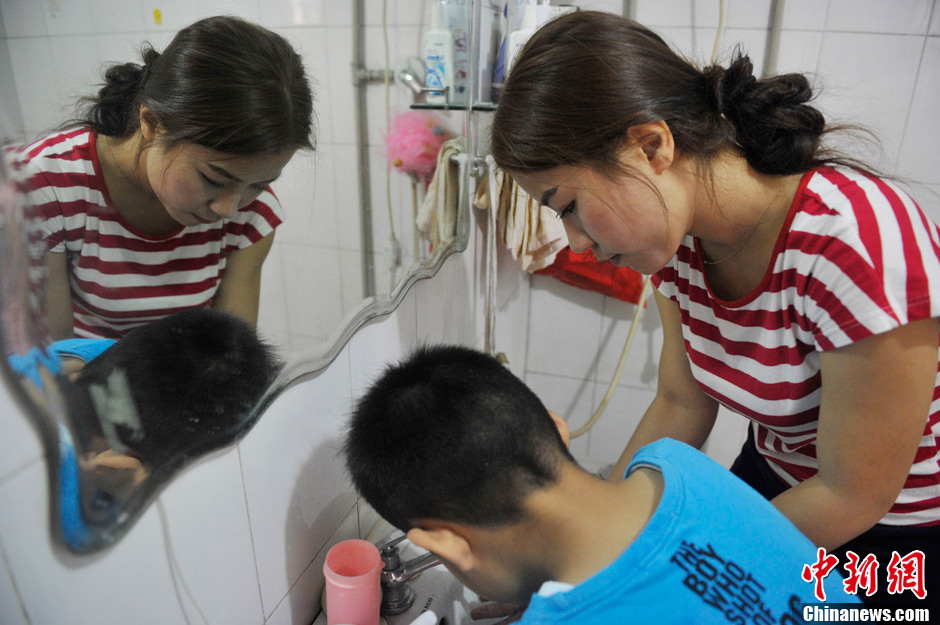 A volunteer washes a child’s hands before lunch. It has been 5 years since Li established the non-profit classroom specifically for children with autism in Taiyuan, north China’s Shanxi province. (Photo by Weiliang/ Chinanews.com)
