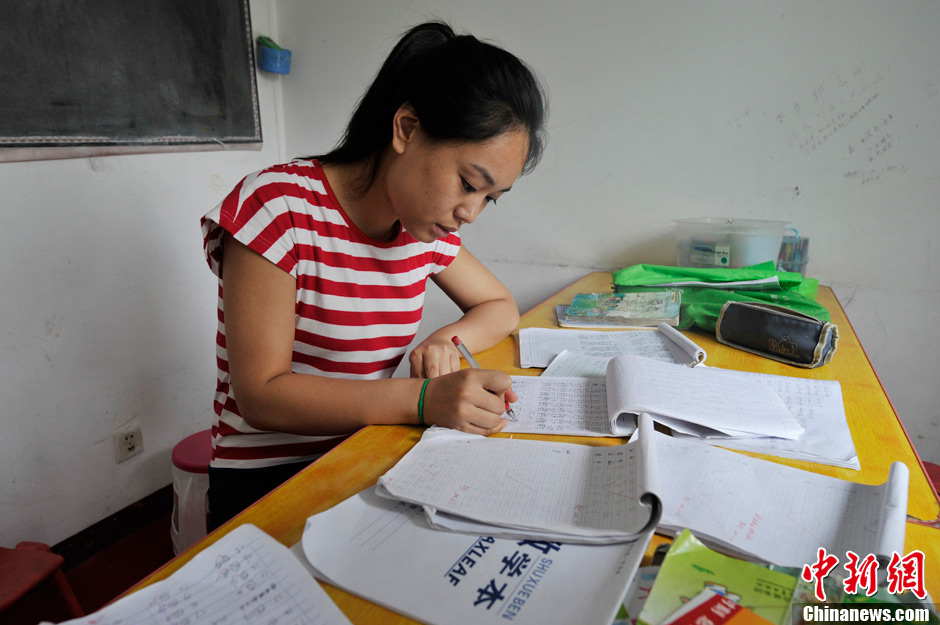 Li Xiaojiao seizes minutes correcting children’s homework during lunch break. It has been 5 years since Li established the non-profit classroom specifically for children with autism in Taiyuan, north China’s Shanxi province. (Photo by Weiliang/ Chinanews.com)