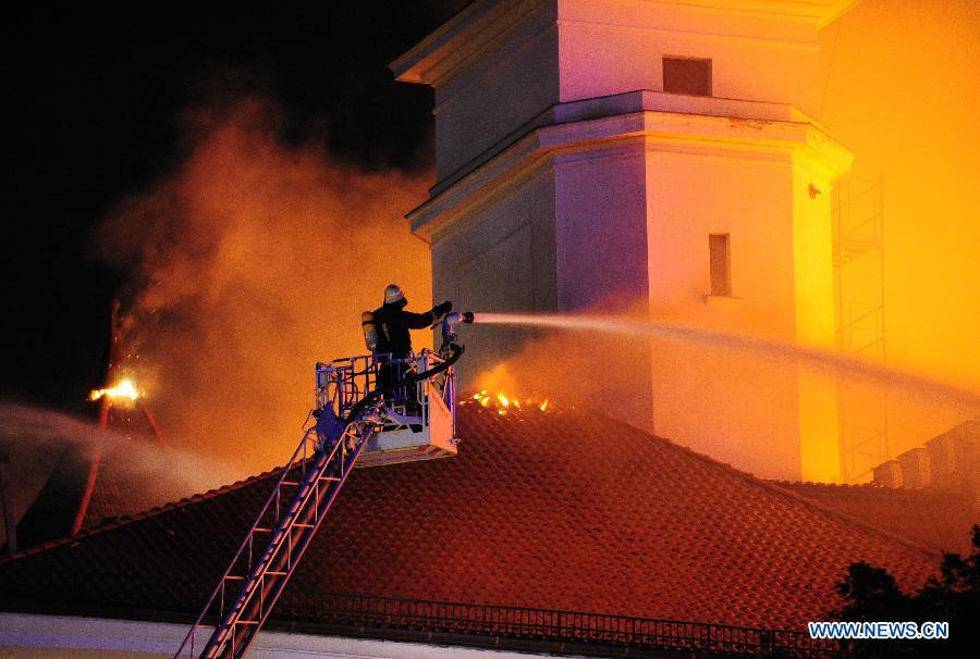 A firefighter tries to extinguish blaze on the roof of Riga Castle, Latvia, June 20, 2013. A massive roof fire was reported at the Riga Castle, office of the Latvian President. No casualty was reported. Due to ongoing renovation, the presidential office was temporarily moved to the Blackheads House, another historic landmark in the Latvian capital. (Xinhua/Guo Qun) 