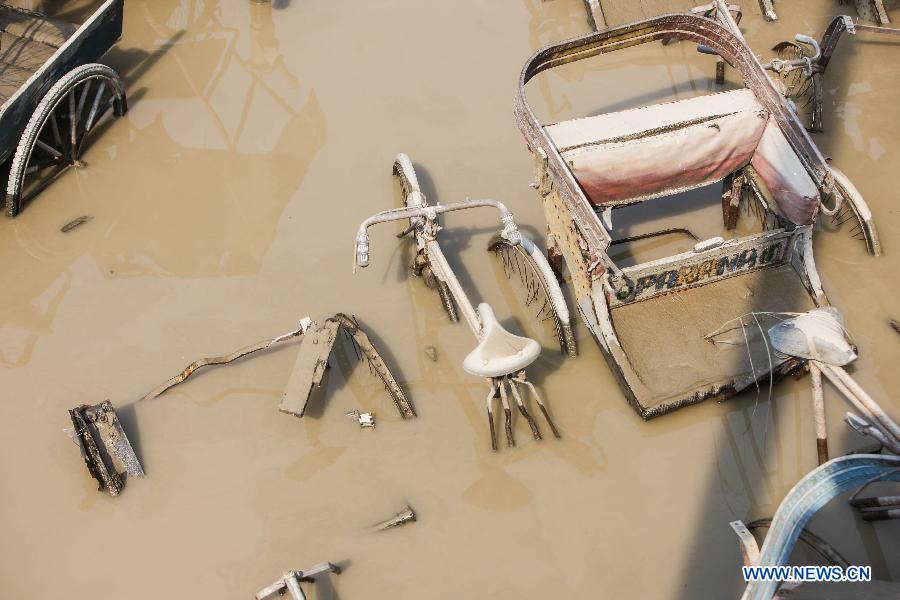 A tricycle and a bicycle are submerged in floodwaters of the Yamuna River in New Delhi, India, June 20, 2013. The Indian capital has been put on flood alert after its main Yamuna river breached the danger mark following incessant rainfall since June 16. So far, more than 150 people have died in Uttarakhand floods, while thousands have been displaced and stranded, according to reports. (Xinhua/Zheng Huansong) 