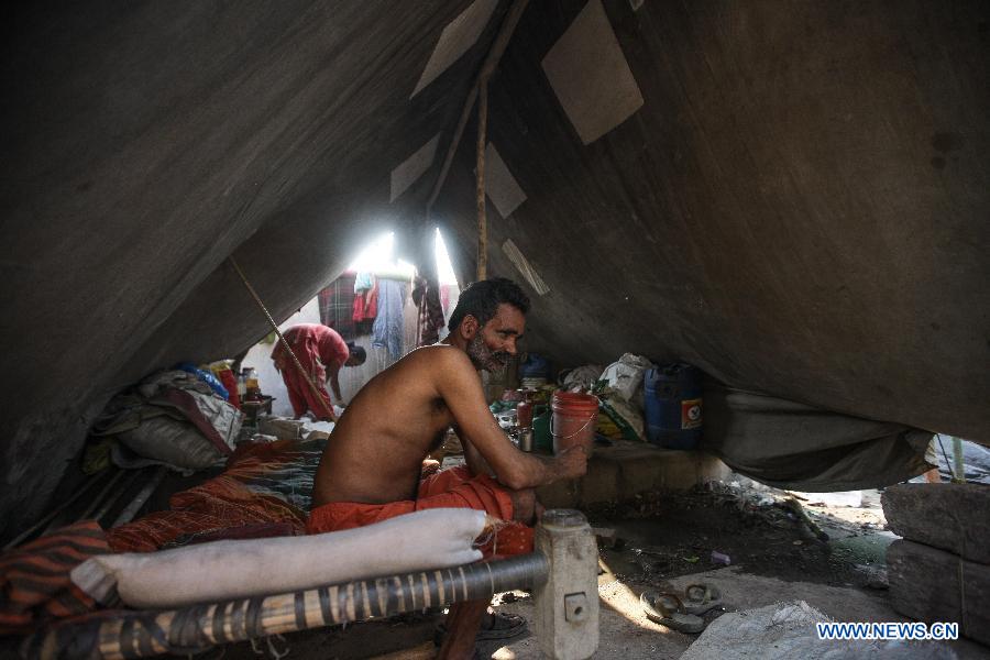 A couple live in a tent as their house was submerged by floodwaters of the Yamuna River in New Delhi, India, June 20, 2013. The Indian capital has been put on flood alert after its main Yamuna river breached the danger mark following incessant rainfall since June 16. So far, more than 150 people have died in Uttarakhand floods, while thousands have been displaced and stranded, according to reports. (Xinhua/Zheng Huansong) 
