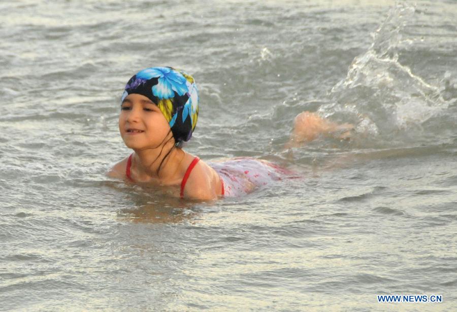 A child swims at Dadonghai in Sanya, south China's Hainan Province, June 20, 2013. People took actions to keep away from heat as the temperature in Sanya reached 30 degrees centigrade above recently. (Xinhua/Zhang Yongfeng)