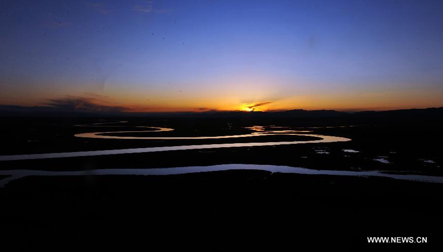 Photo taken on July 17, 2011 shows the scenery of the swan lake at Bayanbulak Grassland on the Tianshan in northwest China's Xinjiang Uygur Autonomous Region. The 37th session of UNESCO's World Heritage Committee (WHC) inscribed China's Xinjiang Tianshan on the World Heritage List as a natural site on June 21, 2013. Xinjiang Tianshan is a serial property totaling 606,833 hectares and consisting of four components which are located along the 1,760 km Tianshan range, a temperate arid zone surrounded by Central Asian deserts.(Xinhua/Jiang Wenyao)