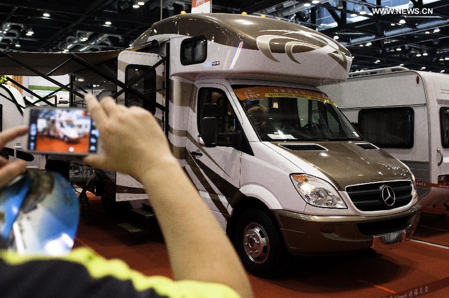 A visitor takes pictures of an RV at the Beijing International Tourism Expo (BITE) 2013 in Beijing, capital of China, June 21, 2013. The BITE 2013 kicked off on Friday, attracting 887 exhibitors from 81 countries and regions. (Xinhua/Liu Jinhai) 