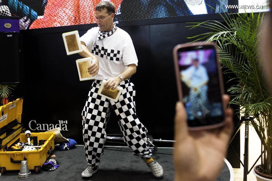 An artist performs at the Beijing International Tourism Expo (BITE) 2013 in Beijing, capital of China, June 21, 2013. The BITE 2013 kicked off on Friday, attracting 887 exhibitors from 81 countries and regions. (Xinhua/Liu Jinhai)