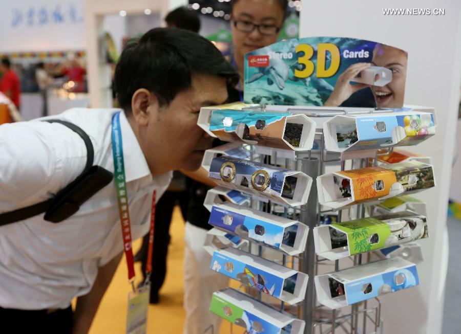 A visitor views 3D tourism souvenirs at the Beijing International Tourism Expo (BITE) 2013 in Beijing, capital of China, June 21, 2013. The BITE 2013 kicked off on Friday, attracting 887 exhibitors from 81 countries and regions. (Xinhua/Zhang Yu)