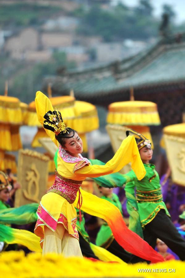 Dancers dressed in ancient costumes perform during a sacrifice ceremony at "the Temple of Fu Xi" in Tianshui, northwest China's Gansu Province, June 22, 2013. More than 20,000 Chinese from China and abroad attended a sacrifice ceremony held here Saturday to pay tribute to Fu Xi, a culture hero who is believed to be the inventor of writing, fishing and hunting. Fu Xi is regarded as one of the ancestors of the Chinese nation. (Xinhua/Chen Bin) 