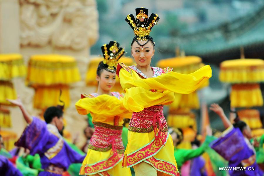 Dancers dressed in ancient costumes perform during a sacrifice ceremony at "the Temple of Fu Xi" in Tianshui, northwest China's Gansu Province, June 22, 2013. More than 20,000 Chinese from China and abroad attended a sacrifice ceremony held here Saturday to pay tribute to Fu Xi, a culture hero who is believed to be the inventor of writing, fishing and hunting. Fu Xi is regarded as one of the ancestors of the Chinese nation. (Xinhua/Chen Bin) 