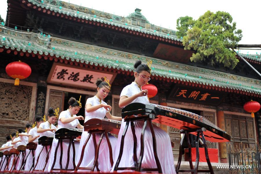 University students perform ancient musical instrument during a sacrifice ceremony at "the Temple of Fu Xi" in Tianshui, northwest China's Gansu Province, June 22, 2013. More than 20,000 Chinese from China and abroad attended a sacrifice ceremony held here Saturday to pay tribute to Fu Xi, a culture hero who is believed to be the inventor of writing, fishing and hunting. Fu Xi is regarded as one of the ancestors of the Chinese nation. (Xinhua/Chen Bin) 