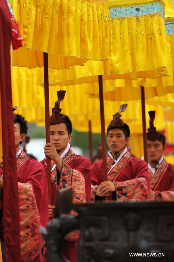 People dressed in ancient costumes are seen during a sacrifice ceremony at "the Temple of Fu Xi" in Tianshui, northwest China's Gansu Province, June 22, 2013. More than 20,000 Chinese from China and abroad attended a sacrifice ceremony held here Saturday to pay tribute to Fu Xi, a culture hero who is believed to be the inventor of writing, fishing and hunting. Fu Xi is regarded as one of the ancestors of the Chinese nation. (Xinhua/Chen Bin) 