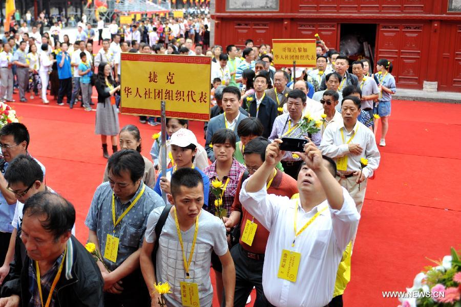 Representatives of the Chinese communities across the globe queue up to attend a sacrifice ceremony at "the Temple of Fu Xi" in Tianshui, northwest China's Gansu Province, June 22, 2013. More than 20,000 Chinese from China and abroad attended a sacrifice ceremony held here Saturday to pay tribute to Fu Xi, a culture hero who is believed to be the inventor of writing, fishing and hunting. Fu Xi is regarded as one of the ancestors of the Chinese nation. (Xinhua/Chen Bin) 