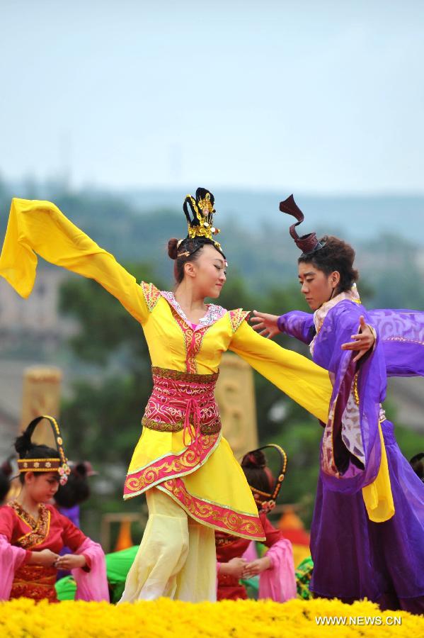 Dancers dressed in ancient costumes perform during a sacrifice ceremony at "the Temple of Fu Xi" in Tianshui, northwest China's Gansu Province, June 22, 2013. More than 20,000 Chinese from China and abroad attended a sacrifice ceremony held here Saturday to pay tribute to Fu Xi, a culture hero who is believed to be the inventor of writing, fishing and hunting. Fu Xi is regarded as one of the ancestors of the Chinese nation. (Xinhua/Chen Bin) 