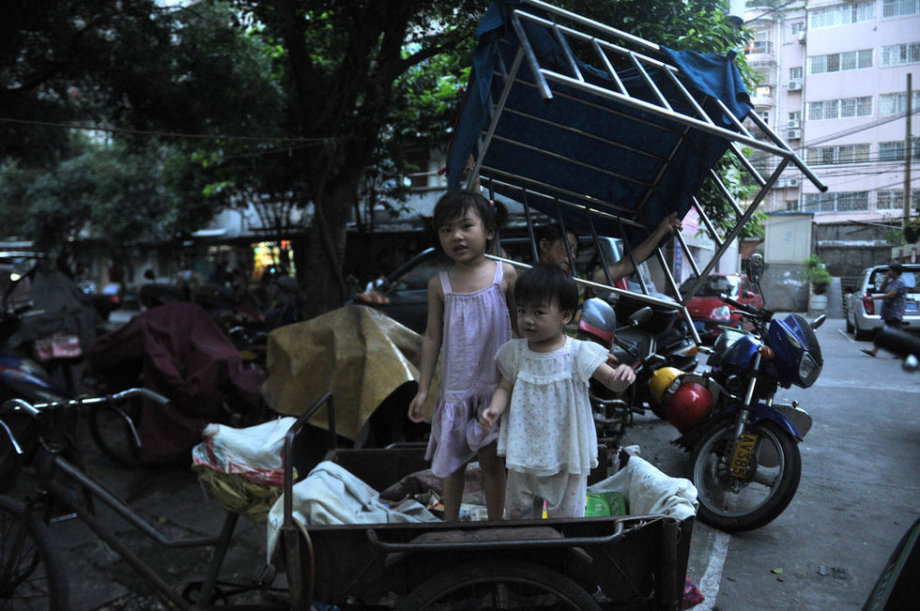 The two girl get out of the cage-like tricycle. (Photo/ youth.cn)
