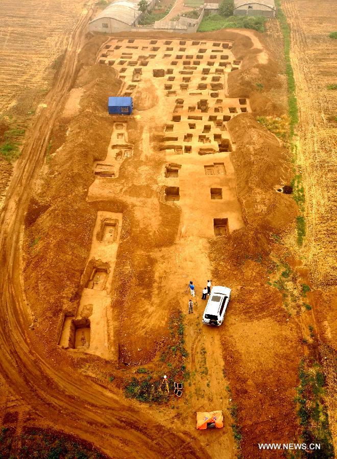 In this photo taken on June 8, 2013, archaeologists work at an ancient burial complex at Guxiang Township in Linying County, central China's Henan Province. Chinese archaeologists have discovered a well-reserved large burial complex dating back to the Warring States Period (475-221 BC) and the West Han (206 B.C.--25 AD.) Dynasty along the local section of the south-to-north water diversion project recently. Some 412 cultural relics have been unearthed in 119 excavated tombs. (Xinhua/Zhu Xiang)
