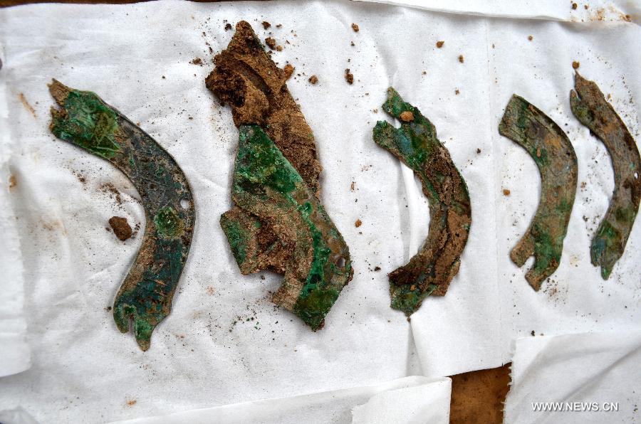Photo taken on June 8, 2013 shows bronze relics found at an ancient burial complex at Guxiang Township in Linying County, central China's Henan Province. Chinese archaeologists have discovered a well-reserved large burial complex dating back to the Warring States Period (475-221 BC) and the West Han (206 B.C.--25 AD.) Dynasty along the local section of the south-to-north water diversion project recently. Some 412 cultural relics have been unearthed in 119 excavated tombs. (Xinhua/Zhu Xiang)