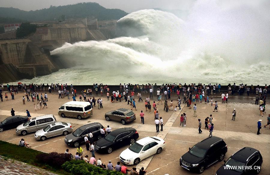 Tourists gather as water gushing out of the Xiaolangdi Reservoir on the Yellow River during a water and sediment regulating operation in Sanmenxia City of central China's Henan Province, June 22, 2013. The water and sediment regulating operation of Xiaolangdi Reservoir is conducted every year to clear out the mud and sand accumulated at the dam. (Xinhua/Wang Song)