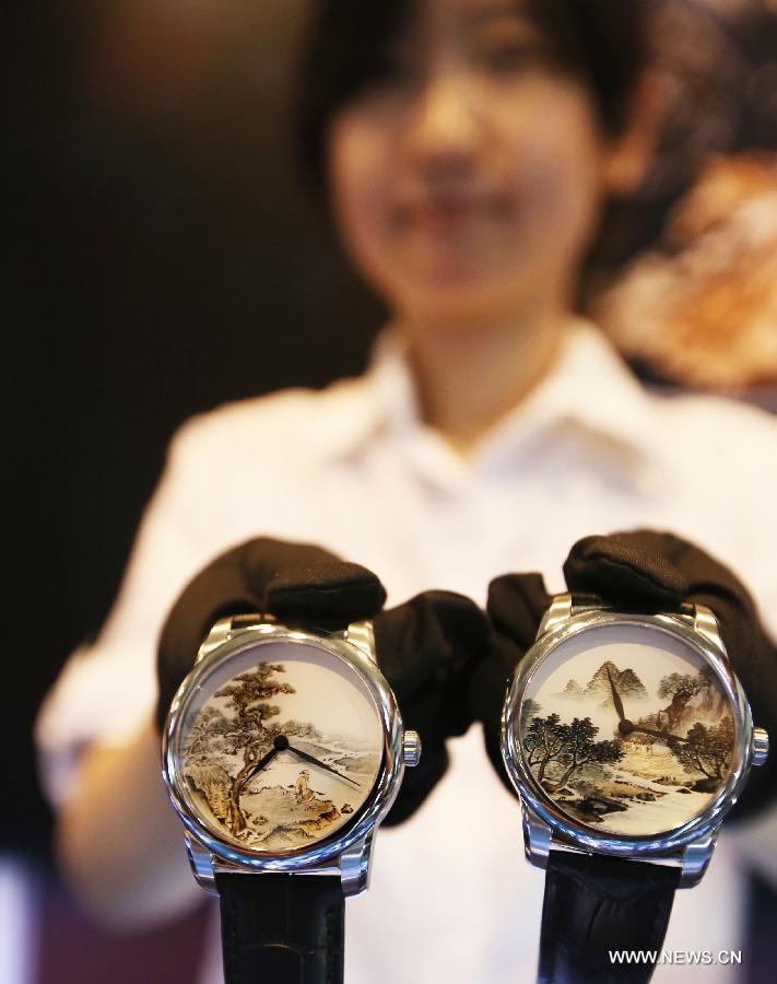 An exhibitor presents watches featuring traditional Chinese painting decoration at the Luxury China 2013 exhibition in Beijing, capital of China, June 22, 2013. The 3-day exhibition kicked off on Saturday, with over 300 exhibitors participated. (Xinhua)