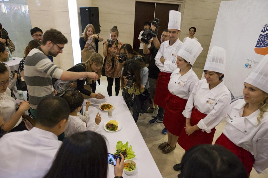 The audience taste the food cooked by the contestants at "Chopsticks and Beyond" Sichuan Cuisine Competition in Beijing, June 22, 2013. "Chopsticks and Beyond" is a Chinese cuisine challenge launched by CRIENGLISH.com to provide a platform for foreign food enthusiasts to show off their Chinese cooking skills and explore creative dishes with exotic flavor. It features China's four great traditions: Sichuan Cuisine, Cantonese Cuisine, Shandong Cuisine and Huaiyang Cuisine.(Xinhuanet/Yang Yi)