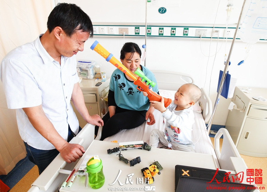 Yang plays game with his father in hospital. . (Photo/vip.people.com.cn)