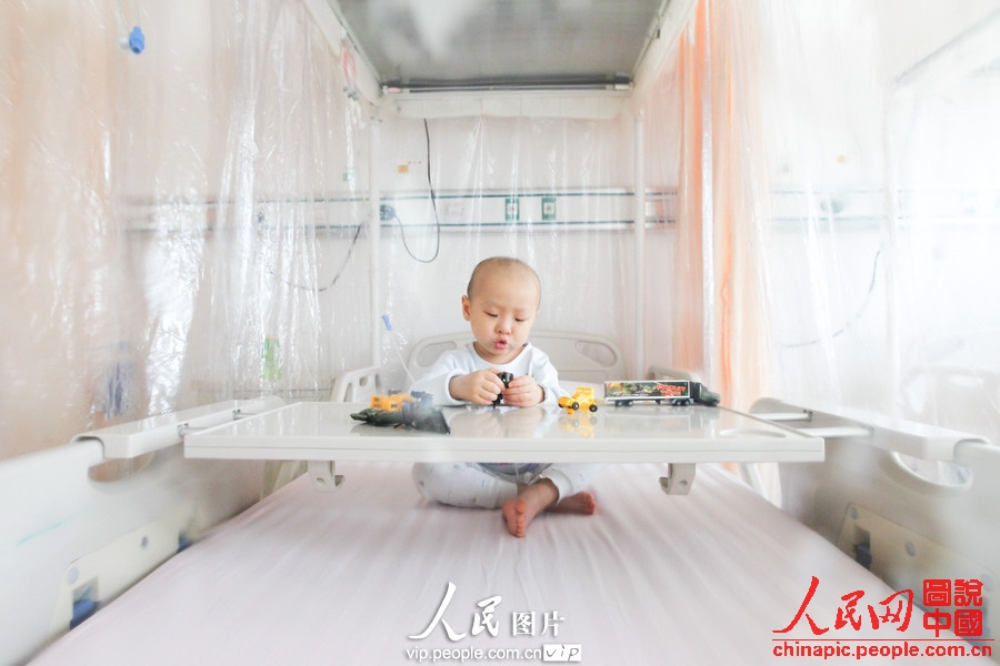 Yang plays toys alone in the sterilized room. (Photo/vip.people.com.cn)