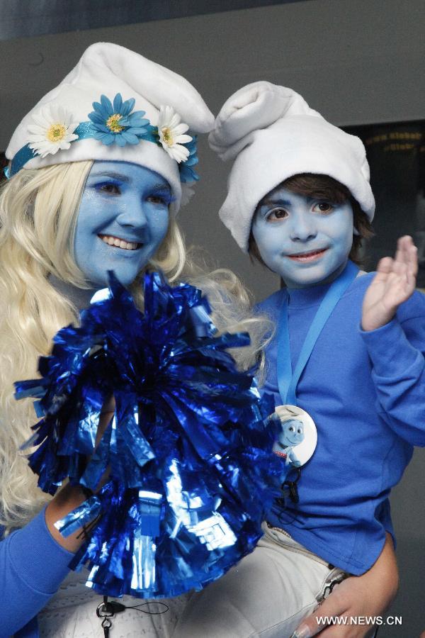 A woman and a boy dress up as the Smurfs during a celebration for the 85th birthday of Peyo, the creator of the Smurfs, on "Global Smurfs Day" in Brussels, capital of Belgium, on June 22, 2013. The event was held ahead of the release of the film "The Smurfs 2", which is premiered in the United States on July 31. (Xinhua/Wang Xiaojun) 