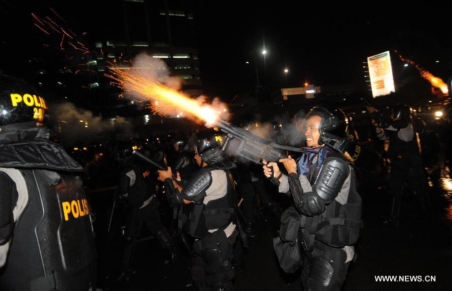 Policemen fire tear gas during clashes with anti-oil price hike demonstrators outside parliament in Jakarta, Indonesia, June 17, 2013. Lawmakers gathered to decide on budget amendments that will pave the way for the first fuel price hikes since 2008. (Xinhua/Zulkarnain) 