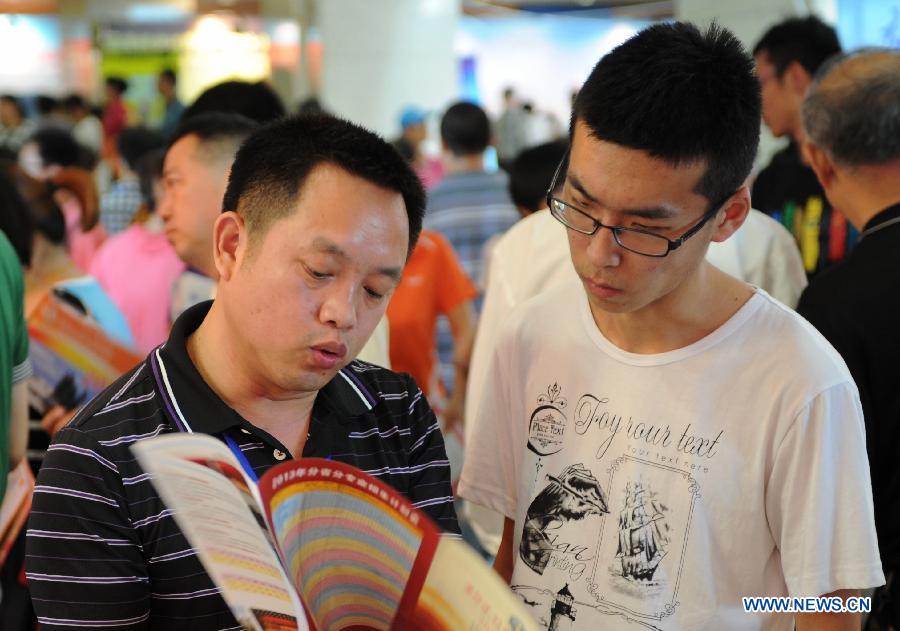 A student (R) inquires information at a college enrollment consultation fair in Shijiazhuang, capital of north China's Hebei Province, June 23, 2013. The fair attracted representatives of nearly 300 colleges. Approximately 9.12 million people all over China took part in the National College Entrance Examination early June. (Xinhua/Wang Xiao)