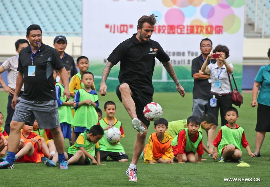 Recently retired football player David Beckham takes part in a training session with students at Nanjing Olympic Center in Nanjing, east China's Jiangsu Province, June 18, 2013. Beckham is on a seven-day visit to China as the ambassador for the Football Programme in China and China's Super League. (Xinhua/Yang Lei)