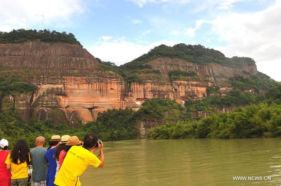 Tourists take photos while visiting Mountain Danxiashan, in Shaoguan City, south China's Guangdong Province, June 22, 2013. Mountain Danxiashan entered a peak tourist season recently with the coming of summer. (Xinhua/Chen Haining)