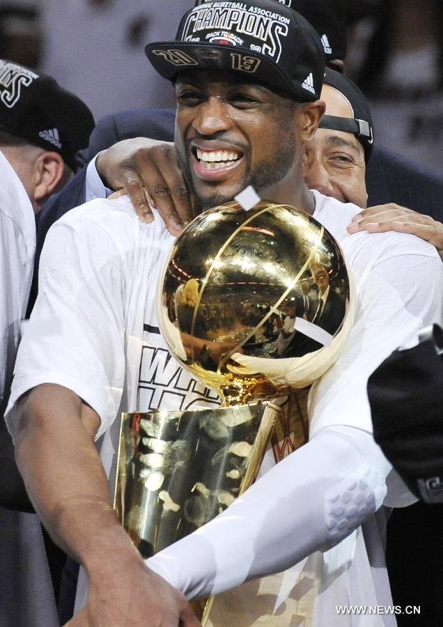 Dwyane Wade of Miami Heat holds the trophy after the game 7 of the NBA finals against San Antonio Spurs in Miami, the United States, on June 20, 2013. Heat defeated Spurs 95-88 and won the champion. (Xinhua/Fang Zhe)